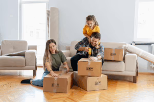 A family packs up boxes in their living room after selling their home for cash